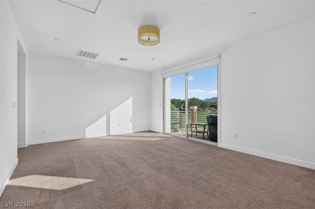 1100 East Sunset Road Henderson, NV 89011 - Photo 35 of 58 A spacious room offers ample space, connecting seamlessly to an outdoor balcony with picturesque views.