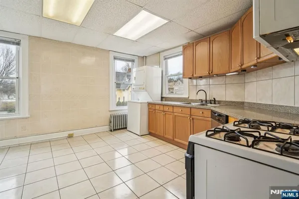 a kitchen with a sink a stove cabinets and a window