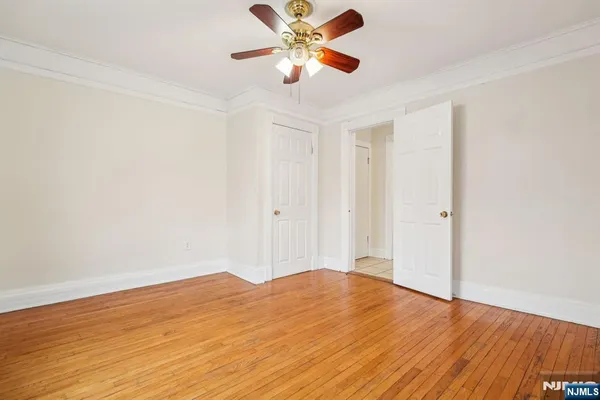 a view of a room with wooden floor and a ceiling fan