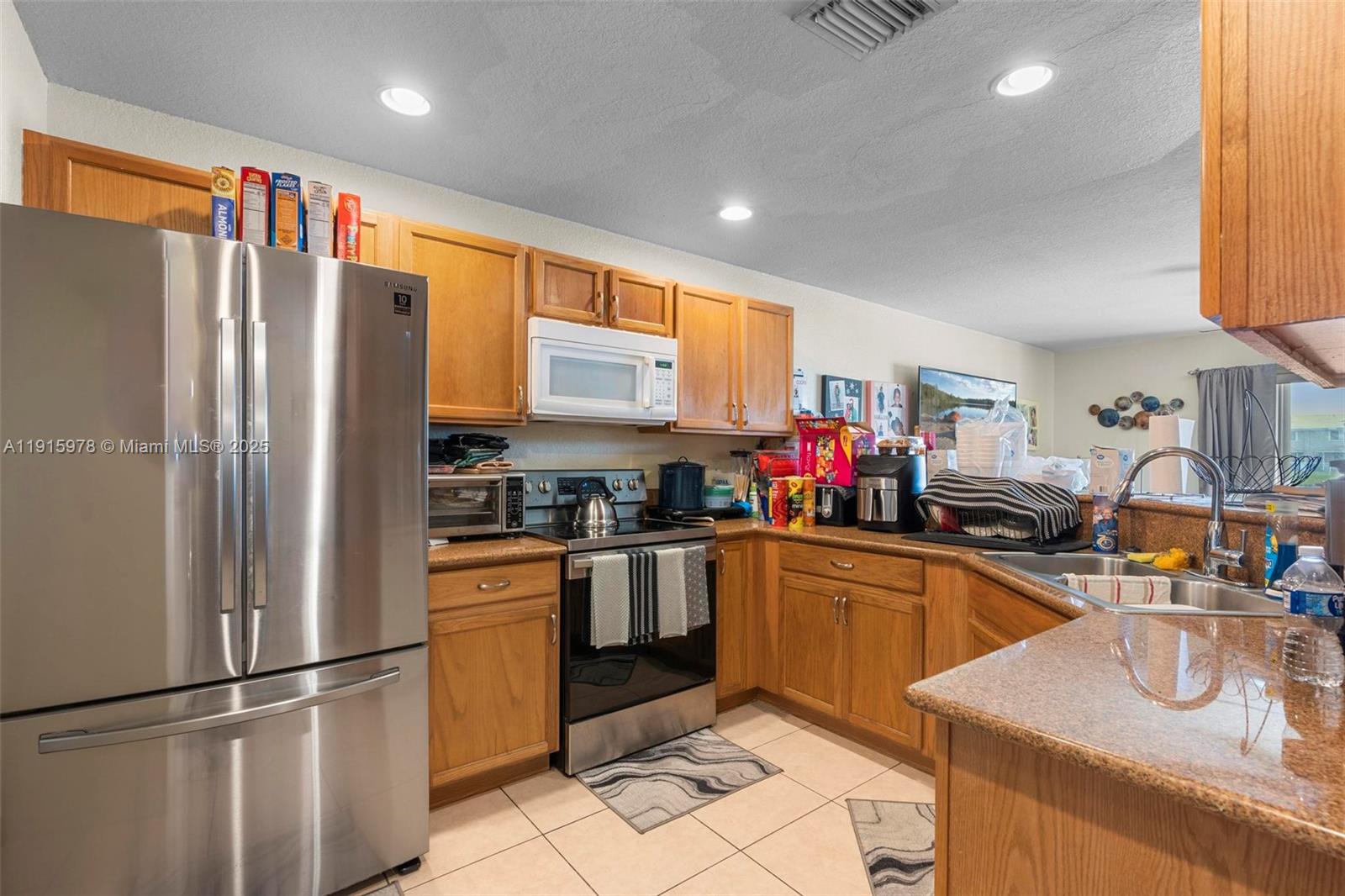 a kitchen with stainless steel appliances granite countertop a refrigerator sink and cabinets