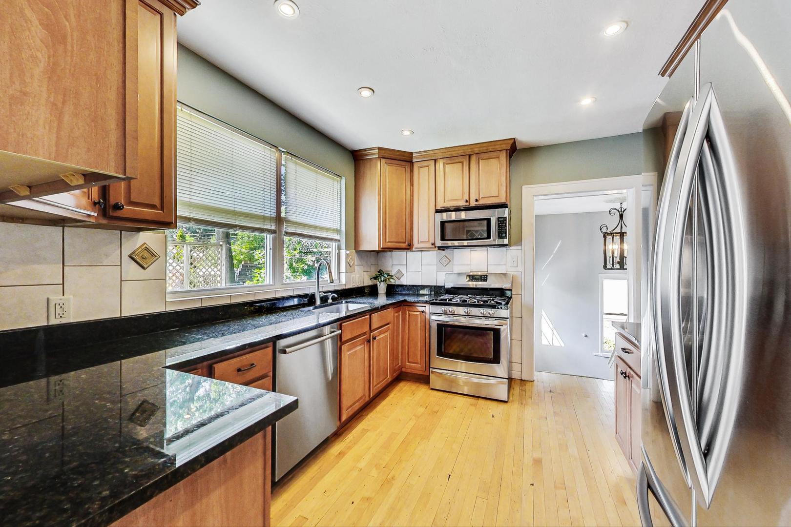 518 South Arlington Heights Road Arlington Heights, IL 60005 - Photo 10 of 42 a kitchen with stainless steel appliances granite countertop a refrigerator a stove and a sink with wooden floor