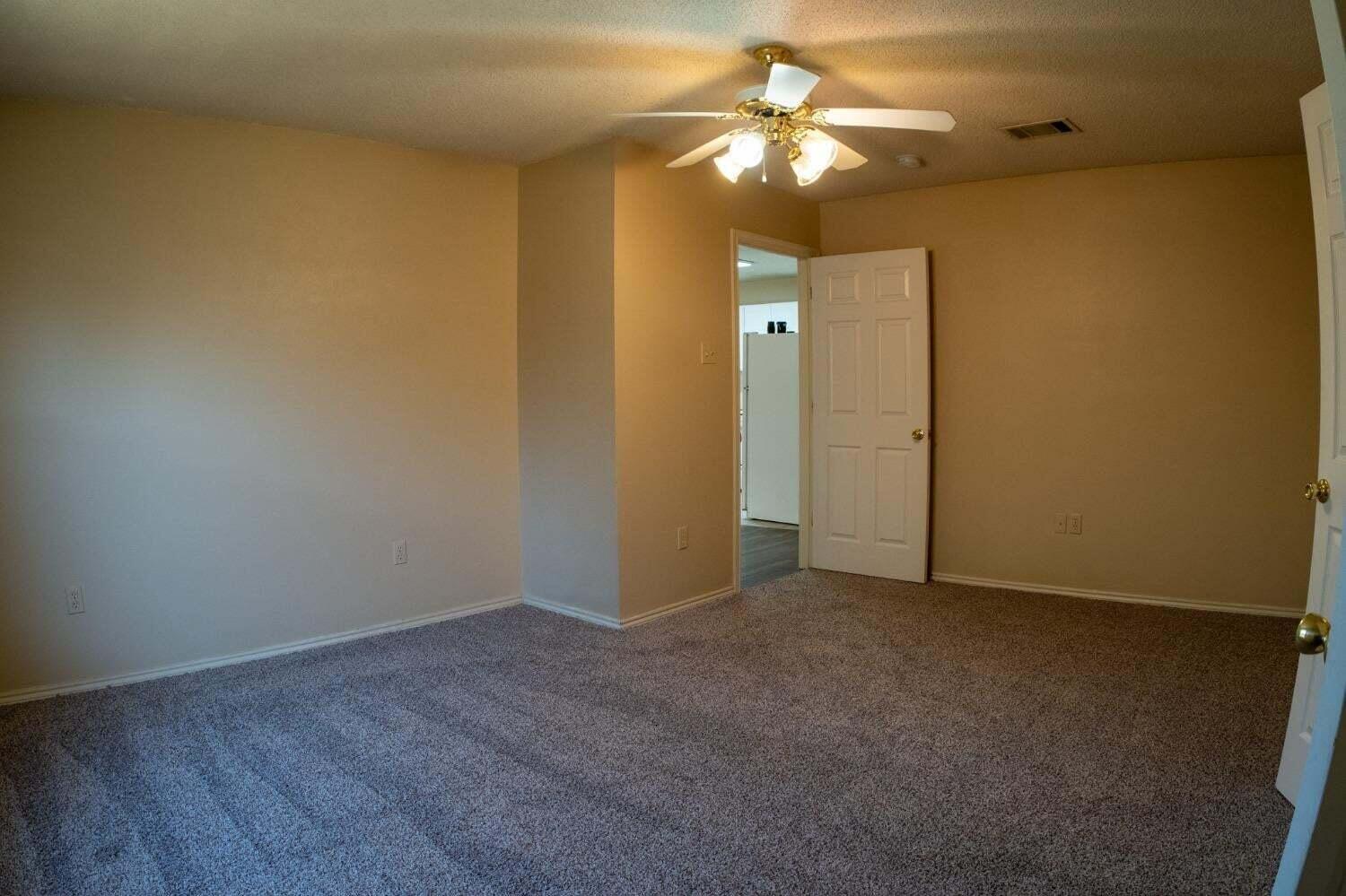 3409 97th Street Lubbock, TX 79423 - Photo 12 of 21 an empty room with a chandelier fan and a chandelier fan