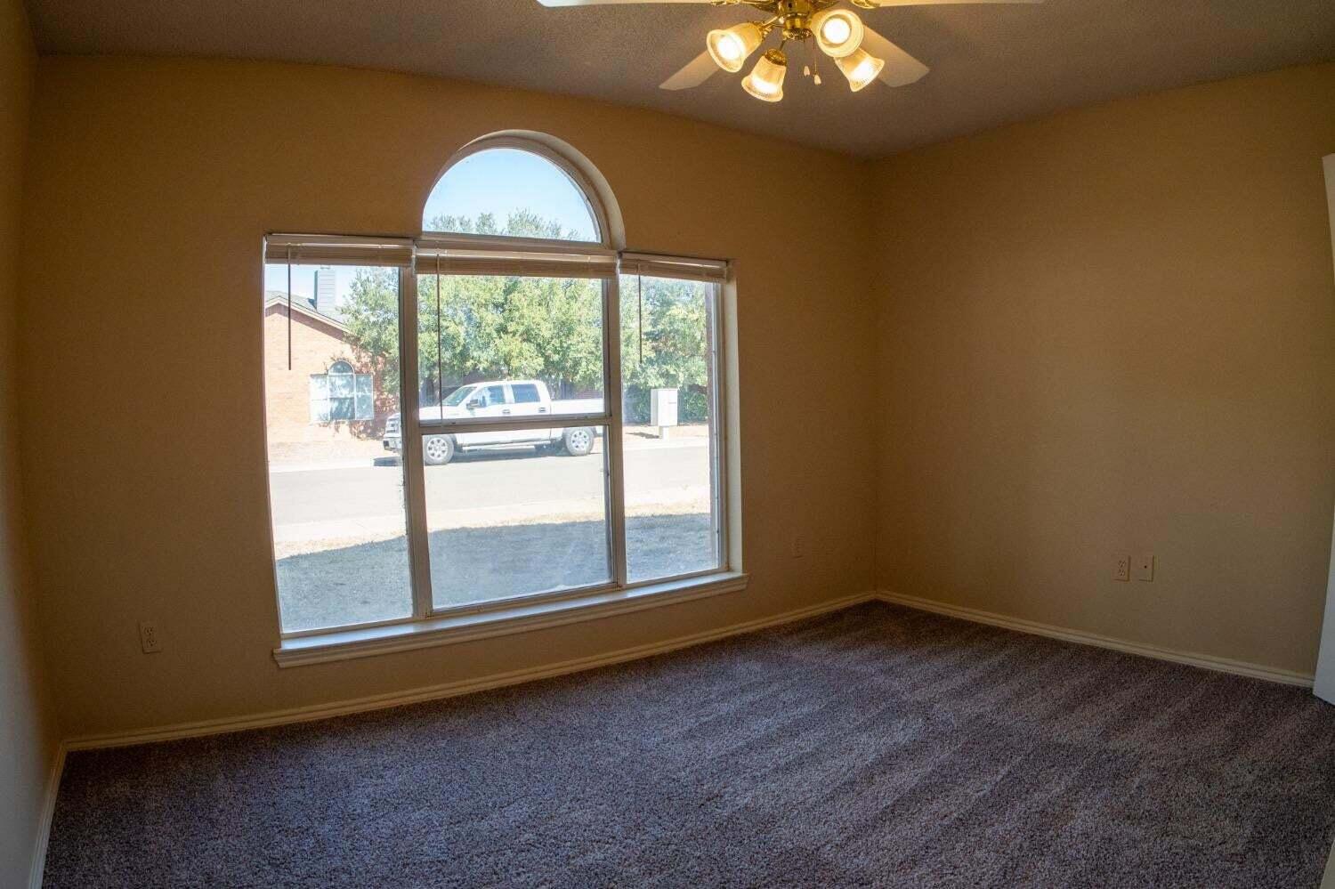 3409 97th Street Lubbock, TX 79423 - Photo 4 of 21 an empty room with a fireplace