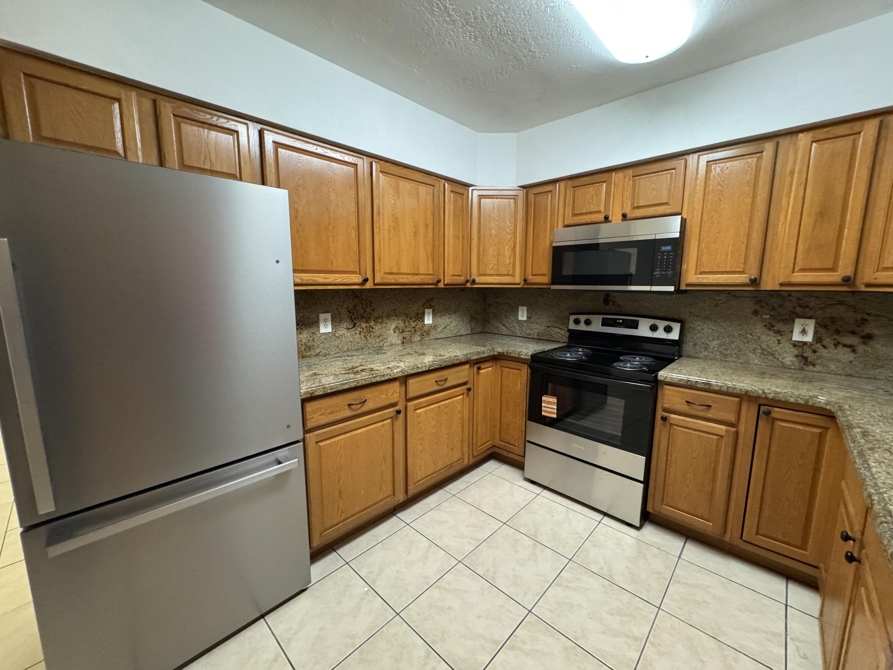 198 Southwest 15th Street Boca Raton, FL 33432 - Photo 4 of 11 a kitchen with stainless steel appliances granite countertop a refrigerator sink and stove
