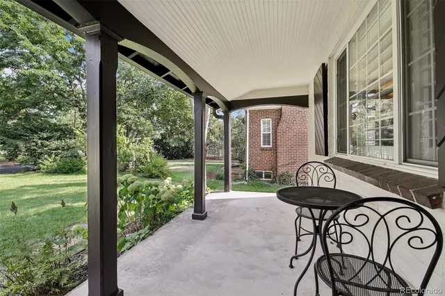 a view of a patio with table and chairs and floor to ceiling window
