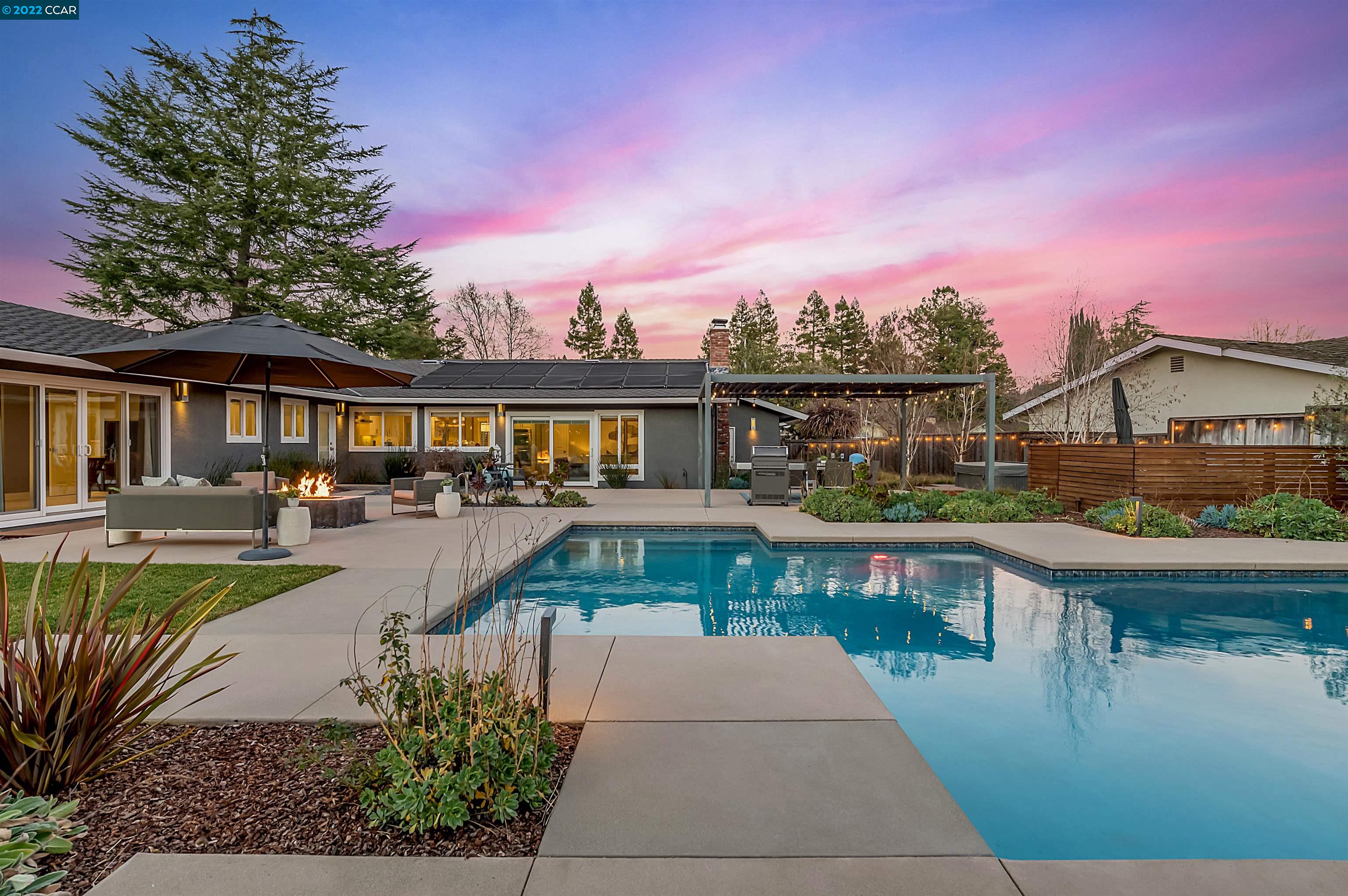 a front view of a house with swimming pool having outdoor seating
