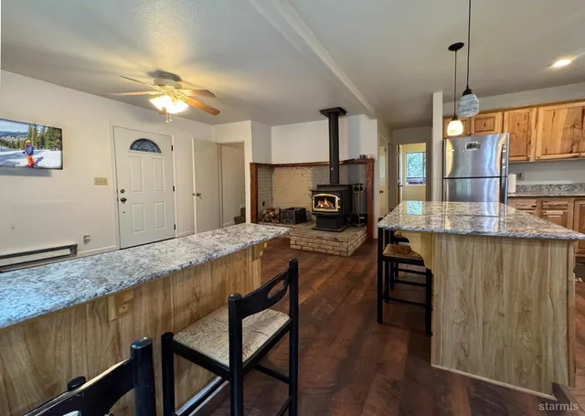 a kitchen with granite countertop a table chairs sink and wooden floor