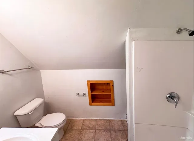 a bathroom with a toilet and a shower curtain