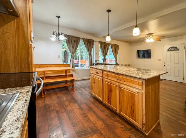 a kitchen with stainless steel appliances granite countertop a sink a stove and a wooden floors