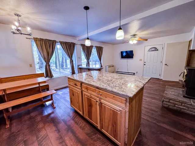 a kitchen with stainless steel appliances granite countertop a stove and a wooden floors