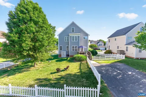 a view of a house with a yard potted plants and a large tree