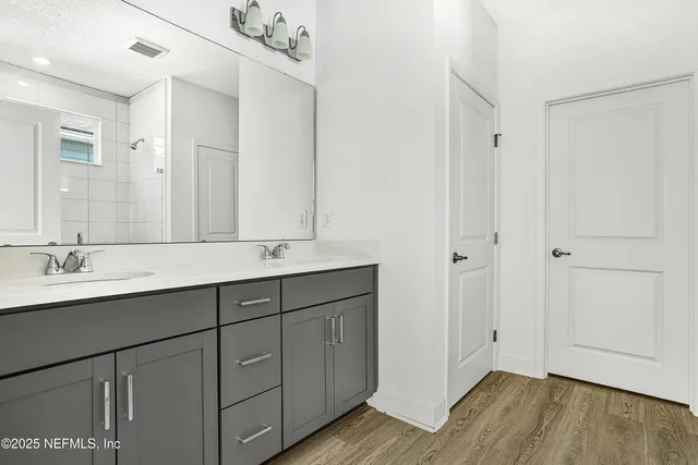 a bathroom with a double vanity sink and mirror