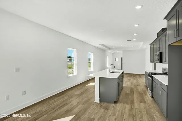 a kitchen with stainless steel appliances granite countertop a sink stove and refrigerator