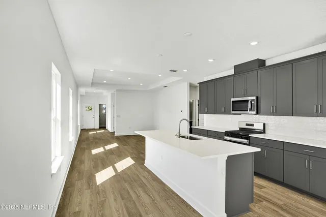 a kitchen with kitchen island sink stove and refrigerator