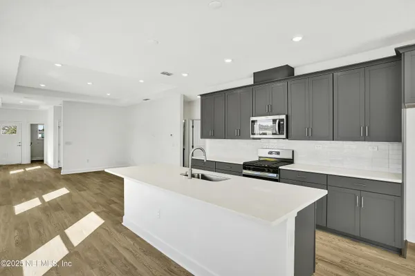 a kitchen with stainless steel appliances a sink a stove a refrigerator and cabinets