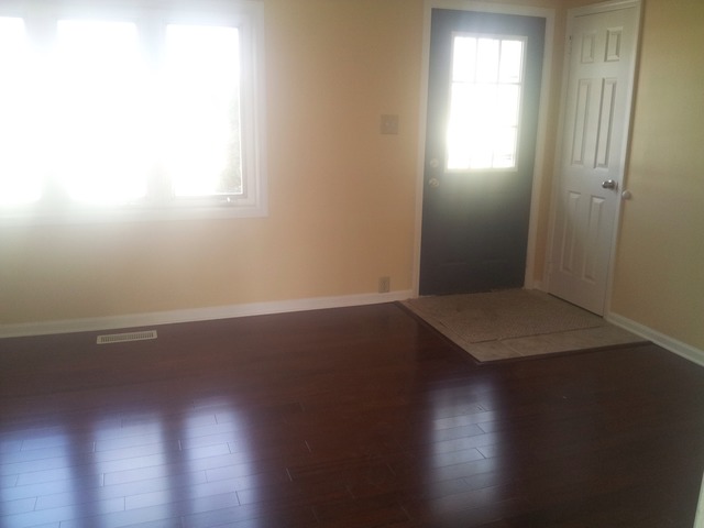 309 Tallman Avenue Romeoville, IL 60446 - Photo 4 of 16 an empty room with wooden floor and windows