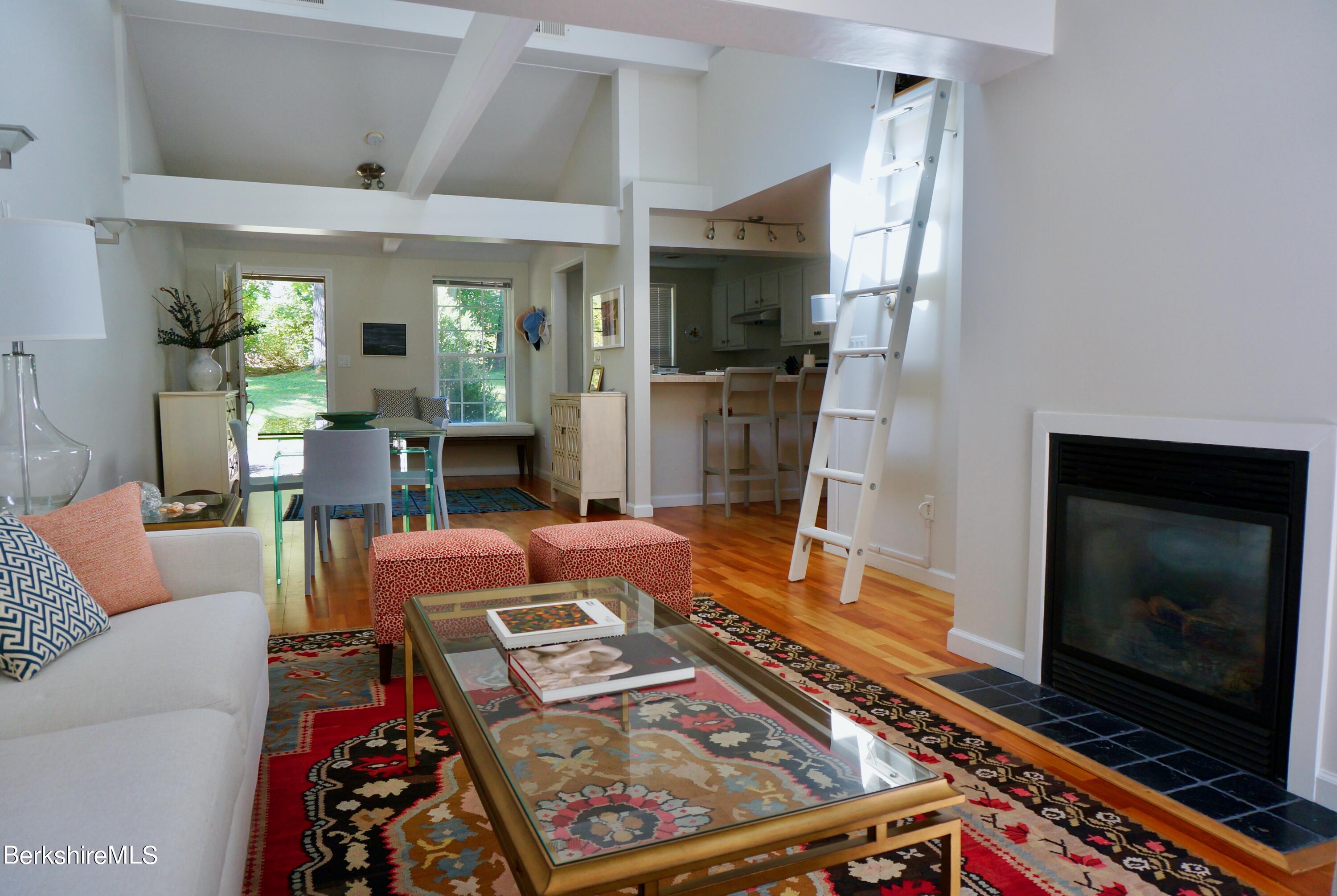 72 Interlaken Road, Unit 1 West Stockbridge, MA 01266 - Photo 3 of 16 a living room with furniture a flat screen tv and a fireplace