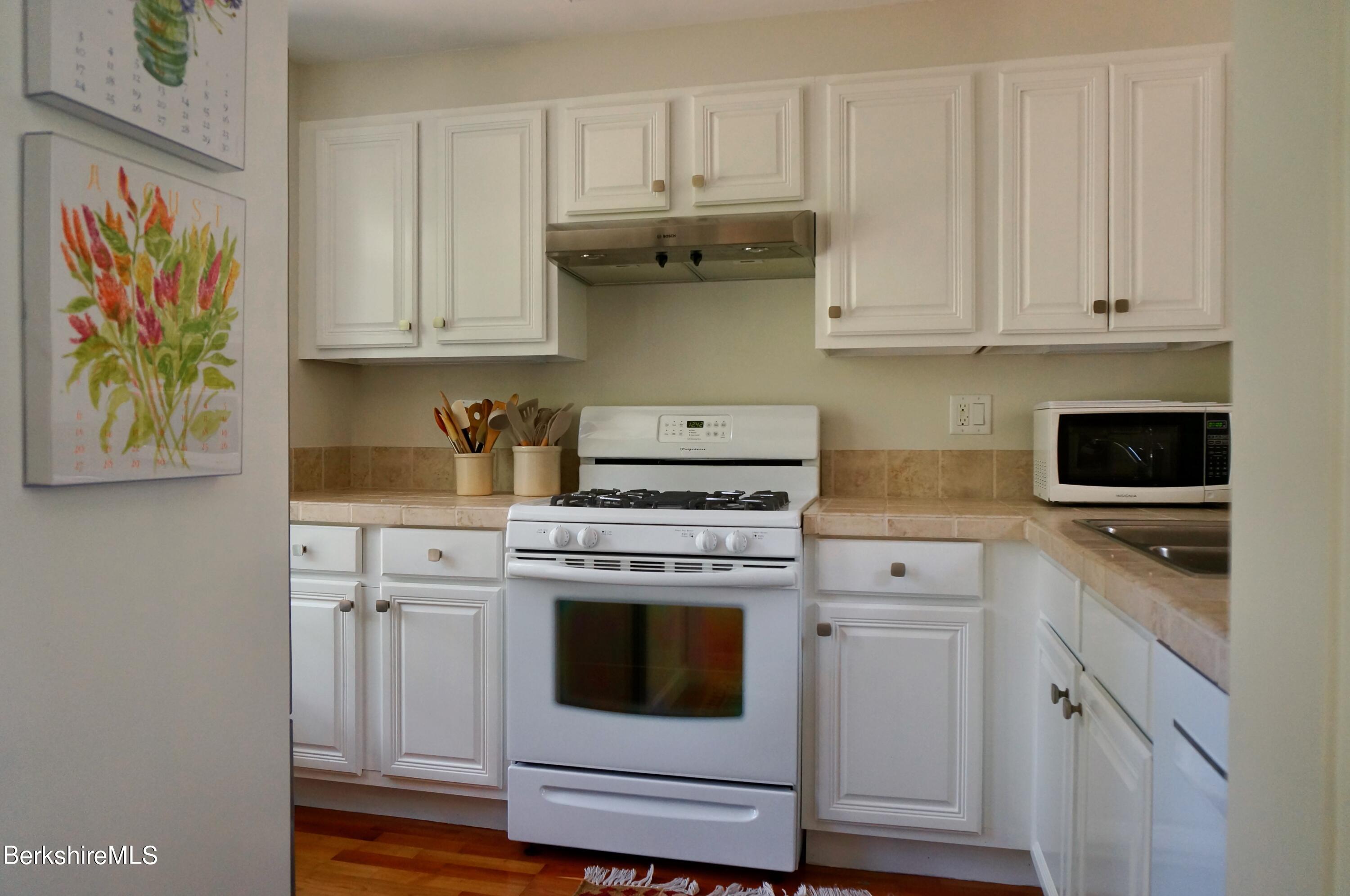 72 Interlaken Road, Unit 1 West Stockbridge, MA 01266 - Photo 8 of 16 a kitchen with granite countertop white cabinets and white appliances