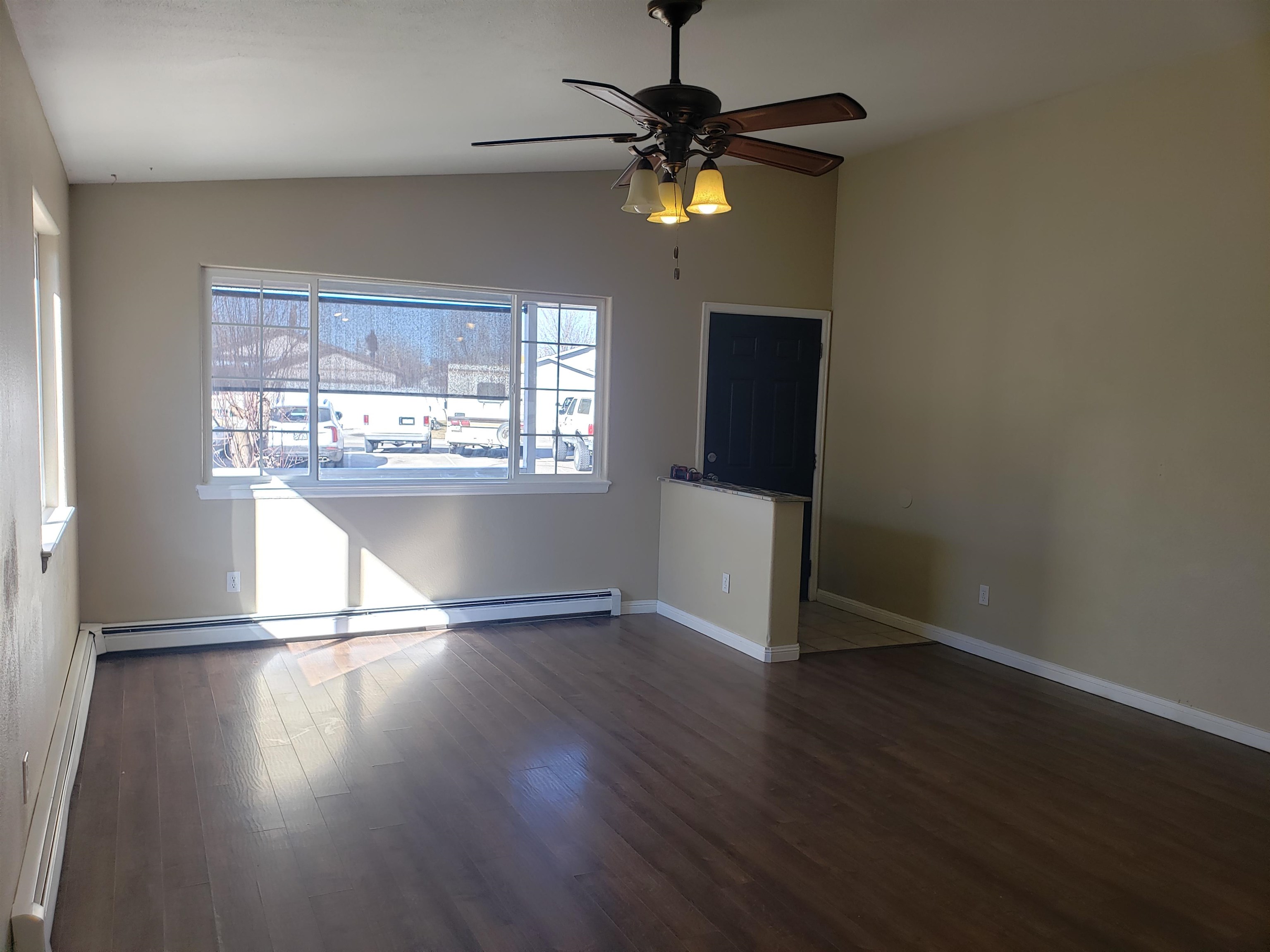 515 Quebec Court Fruita, CO 81521 - Photo 3 of 16 an empty room with wooden floor fan and windows