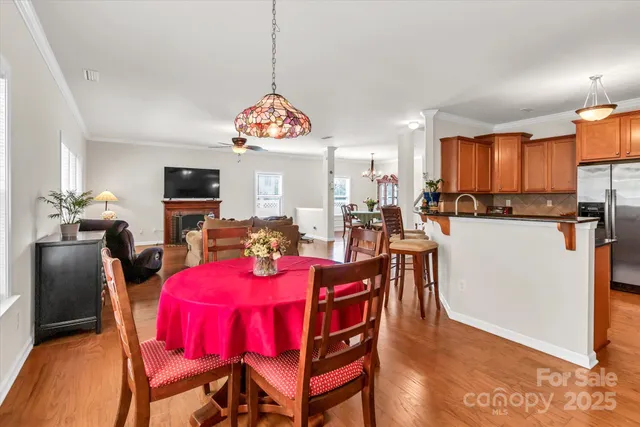 a view of a dining room and livingroom with furniture a flat screen tv a rug and a chandelier