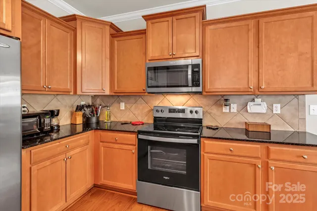 a kitchen with granite countertop wooden cabinets and stainless steel appliances