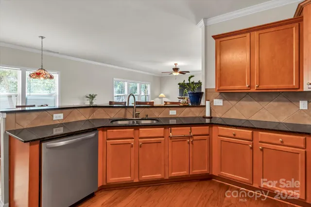 a kitchen with stainless steel appliances granite countertop wooden cabinets and a sink