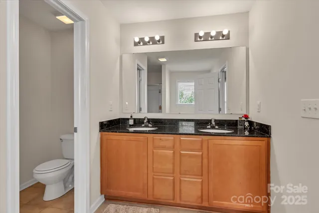 a bathroom with granite countertop a sink and a mirror