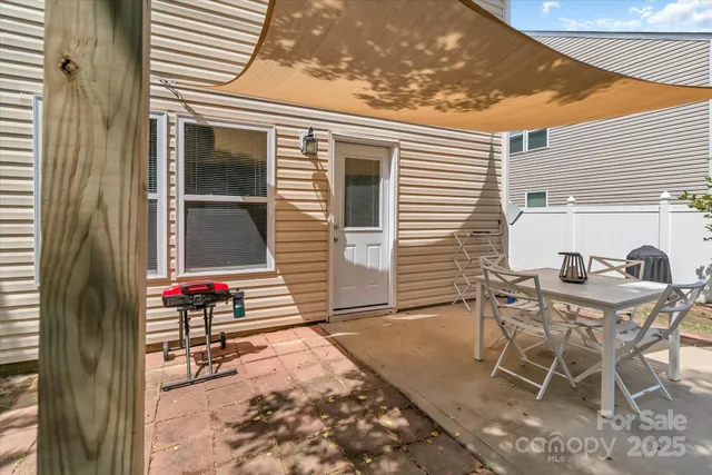 a backyard of a house with table and chairs