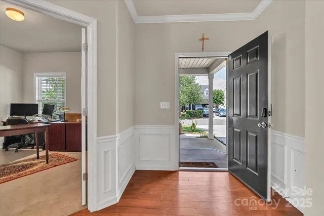 a view of a hallway view with wooden floor and a living room