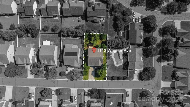 a front view of a house with lots of trees and flowers around