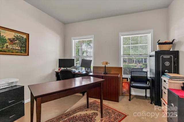 a view of a workspace with furniture and a window