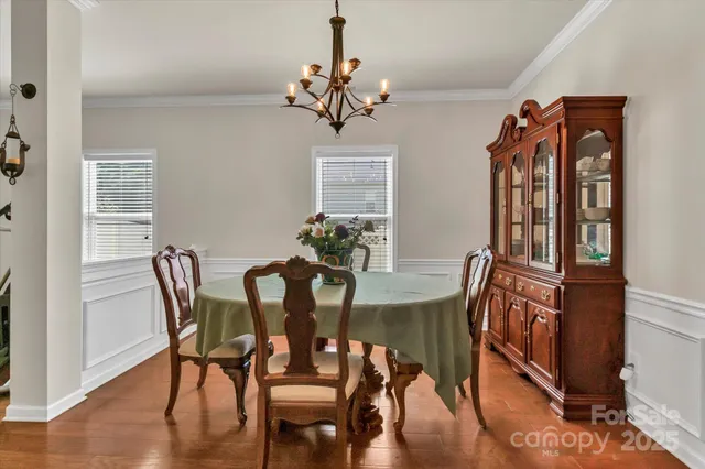 a dining room with furniture potted plants and wooden floor