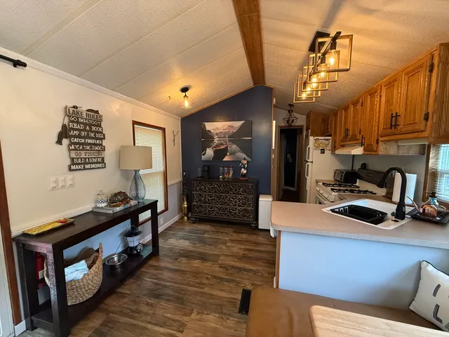 a kitchen with stainless steel appliances kitchen island granite countertop a stove a sink and a refrigerator