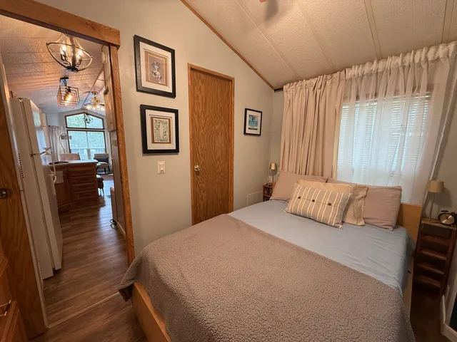 a bedroom with a bed painting on wall and a shower