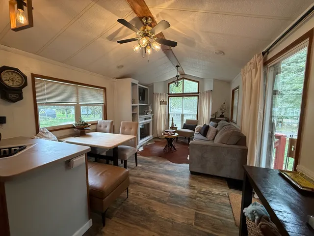 a living room with furniture a flat screen tv and a large window