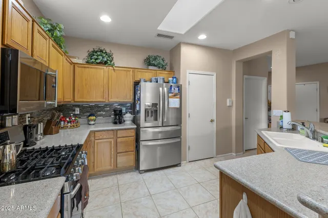 a kitchen with stainless steel appliances a stove a sink and a refrigerator
