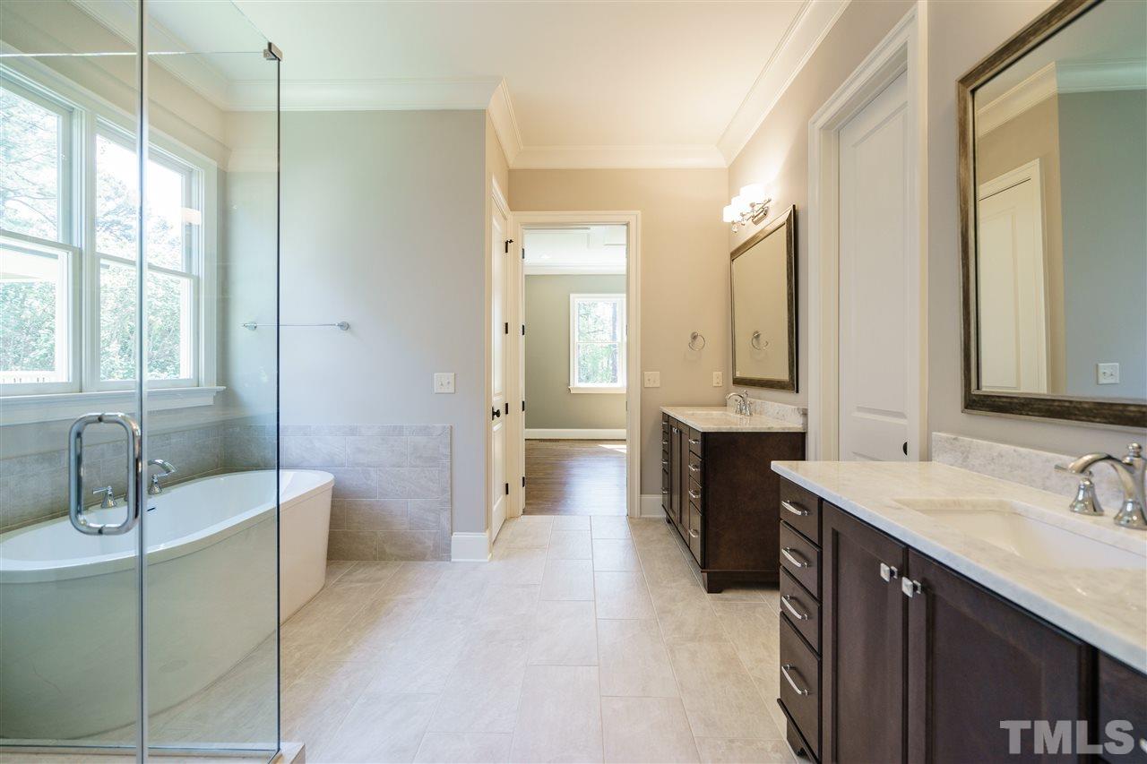 6120 Ponderosa Road Raleigh, NC 27612 - Photo 15 of 25 a spacious bathroom with a double vanity sink tub and mirror