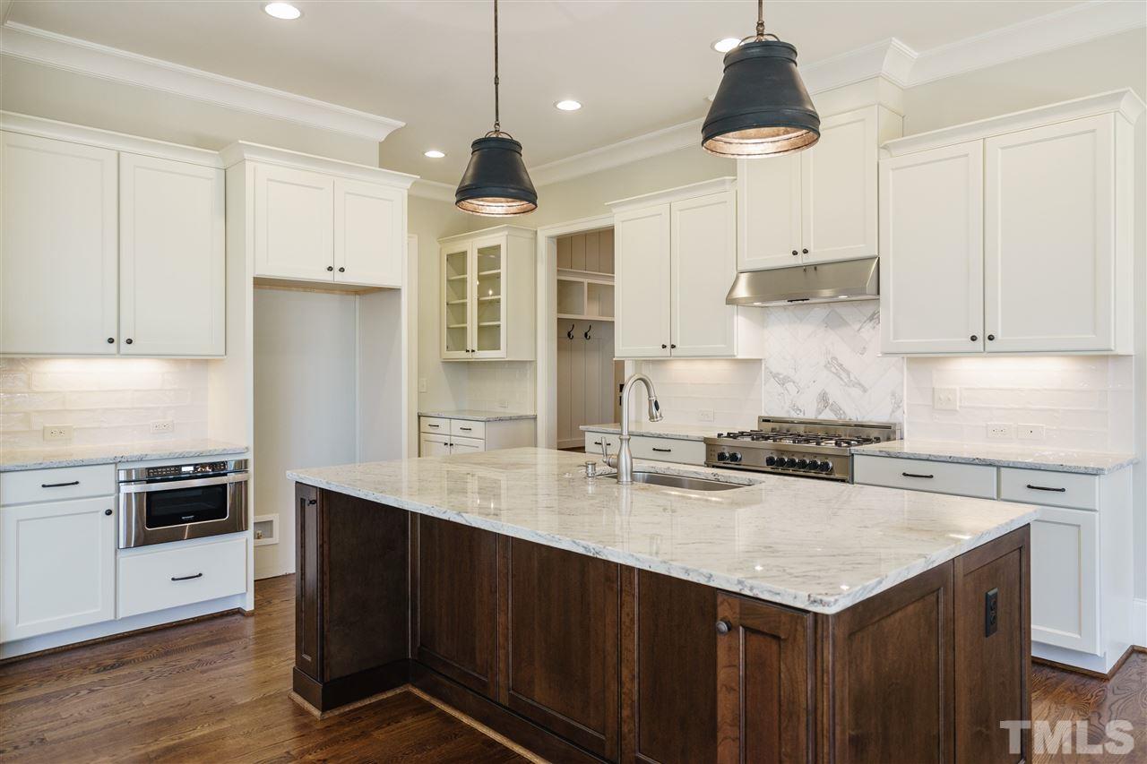 6120 Ponderosa Road Raleigh, NC 27612 - Photo 7 of 25 a kitchen with stainless steel appliances granite countertop a sink a stove and a refrigerator