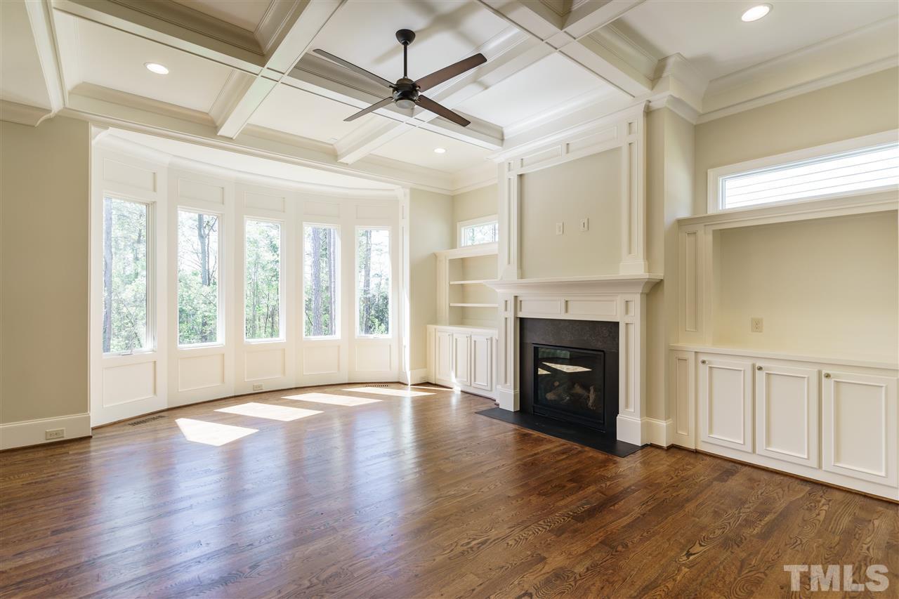 6120 Ponderosa Road Raleigh, NC 27612 - Photo 9 of 25 a view of an empty room with wooden floor fireplace and a window