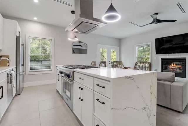 a spacious kitchen with stainless steel appliances granite countertop a sink stove and refrigerator