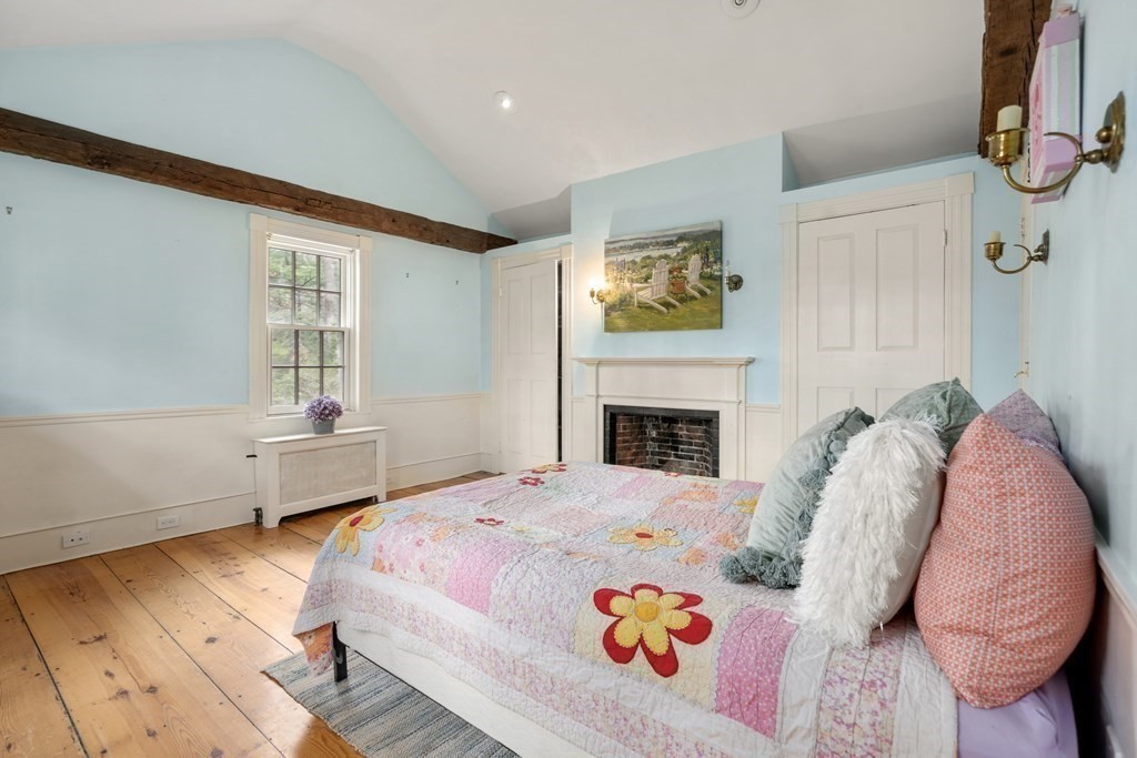 92 Goodnow Road Sudbury, MA 01776 - Photo 19 of 37 a bedroom with a bed a fireplace and a large window