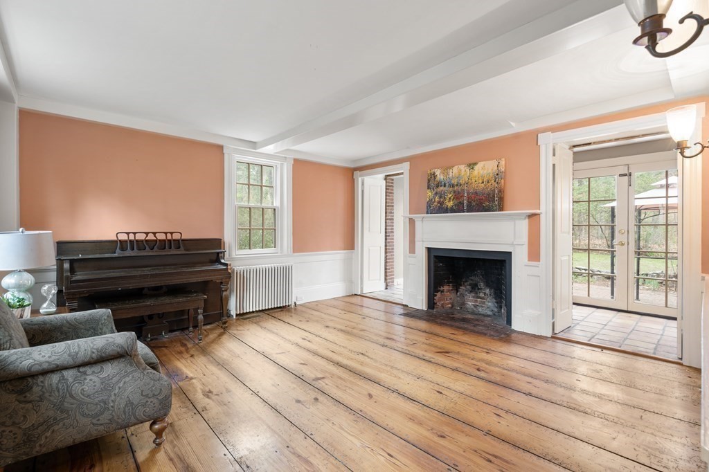 92 Goodnow Road Sudbury, MA 01776 - Photo 10 of 37 a living room with furniture a fireplace and a flat screen tv