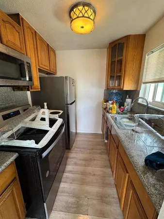 a kitchen with stainless steel appliances granite countertop a stove a sink and a microwave