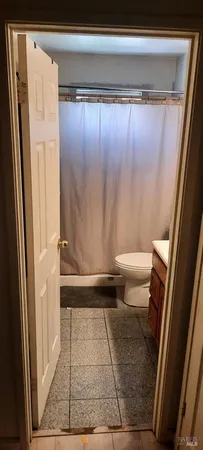 a bathroom with a granite countertop shower and a toilet