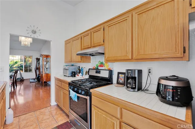 a kitchen with stainless steel appliances granite countertop a stove a sink dishwasher and cabinets with wooden floor