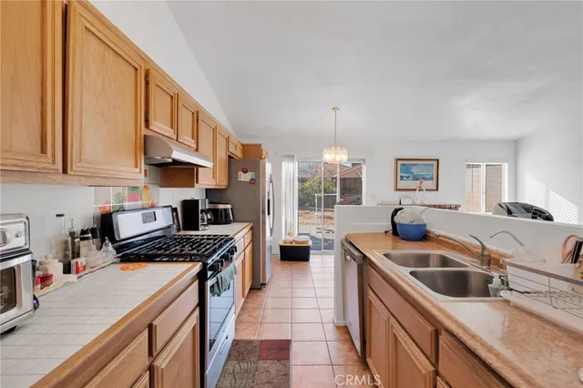 a kitchen with stainless steel appliances granite countertop a sink a stove and a refrigerator