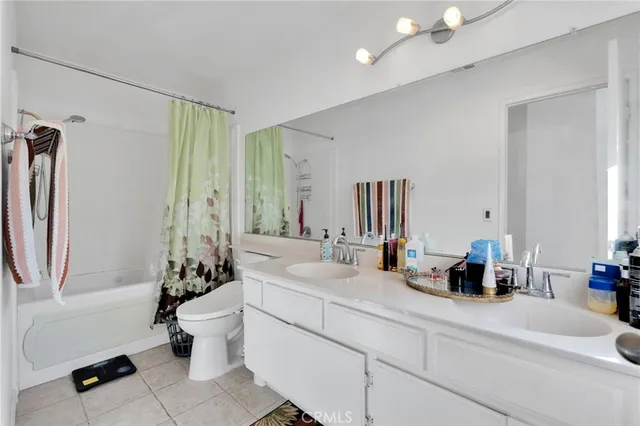 a bathroom with a double vanity sink toilet and shower