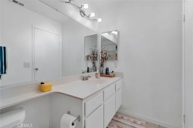a bathroom with a sink a light fixture and a mirror