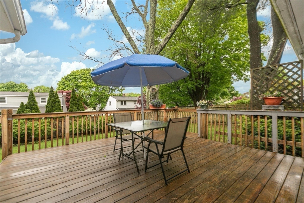 8 Dodge Street Arlington, MA 02474 - Photo 29 of 36 a view of deck with dinning table and chair under an umbrella with wooden floor