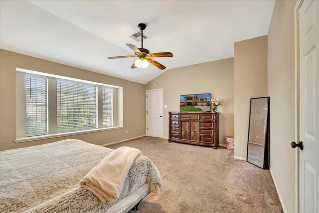 a spacious bedroom with a large bed and a chandelier